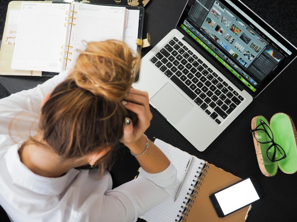 Woman sitting in front of a computer and thinking about Common moving day emergencies