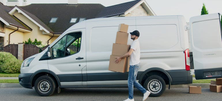 a person carrying boxes out of a truck, tipping movers during your Alexandria move