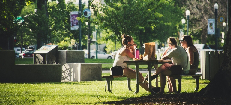 Three Women Sitting On Benches talking about moving to Lanham
