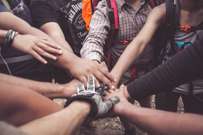 People doing group hand cheer 