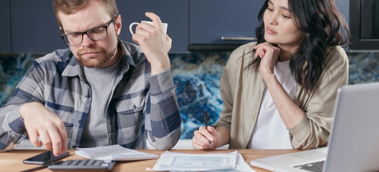 Couple sitting and thinking about moving to an expensive city.