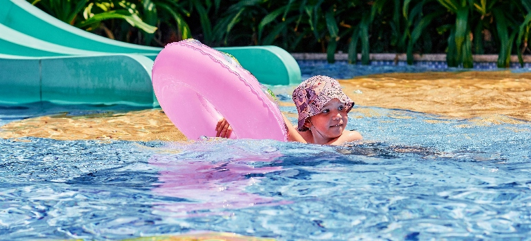 Boy Swimming While Holding a Floater
