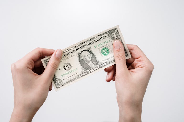 Woman holding one dollar bill and thinking about moving from Alexandria to Annapolis