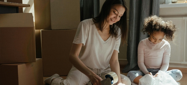 Woman in packing after learning how to support your child through homesickness after relocating.