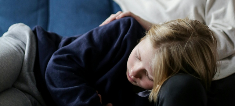 A child laying on a mothers lap