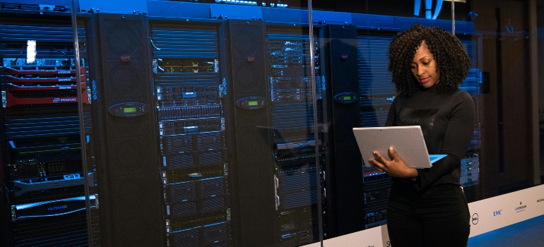 Software Engineer Standing Beside Server Racks, Doing one of the the Highest Paying Professions in VA 