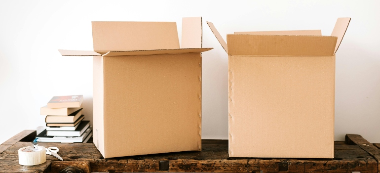 Carboard boxes and stacked books on table