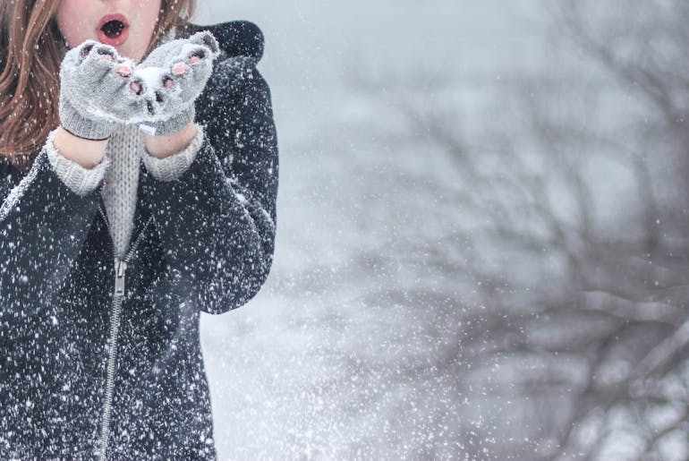 Woman in black jacket thinking about handling heavy items during a winter relocation