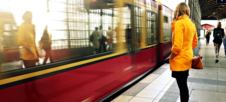 Woman Standing Beside Red Train thinking about Virginia Location for Empty Nesters