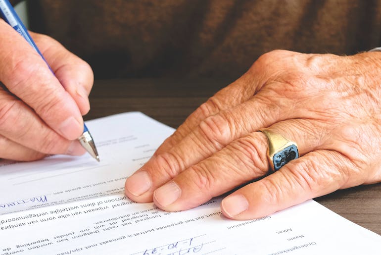 Person signing document and thinking about real estate facts about Washington DC