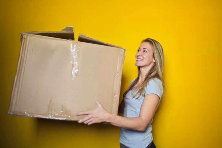 Woman holding a box and thinking about handling a moving day crisis