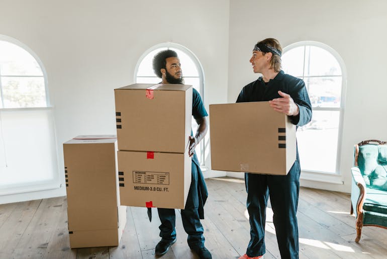 Men standing and holding boxes 