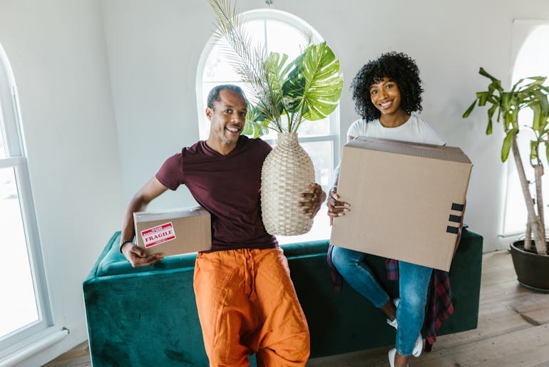 Woman and man holding boxes and sitting 