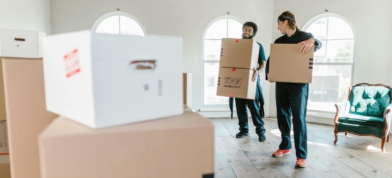 Two Men Carrying Boxes Helping large families moving out of DC 