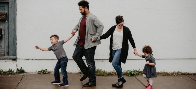 Family Of Four Walking At The Street