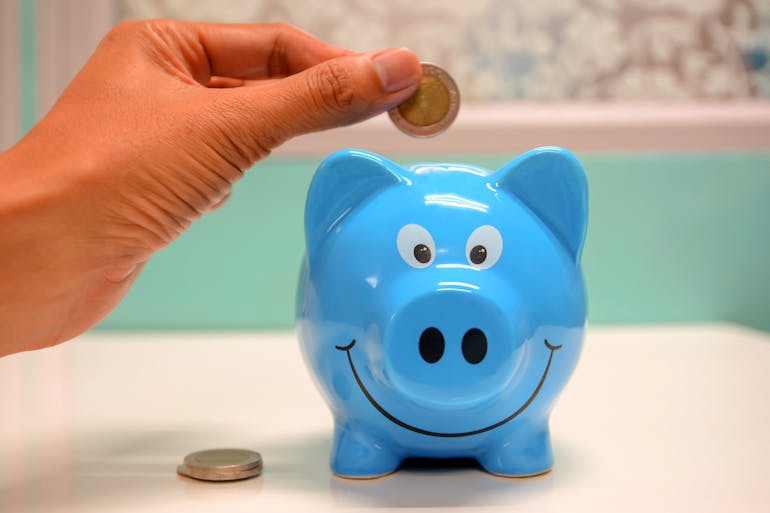 Woman putting coin in a piggy bank and thinking about move from Annapolis to Bowie