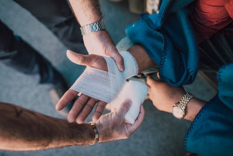 person applying bandages on hand 