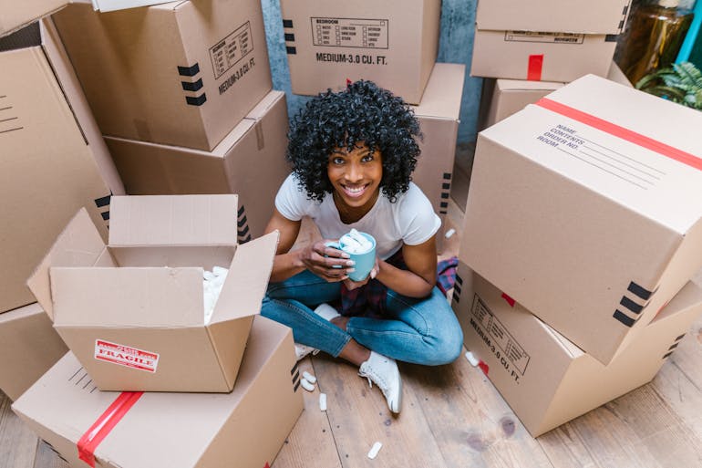 Girl sitting and thinking about packing a glassware for a move