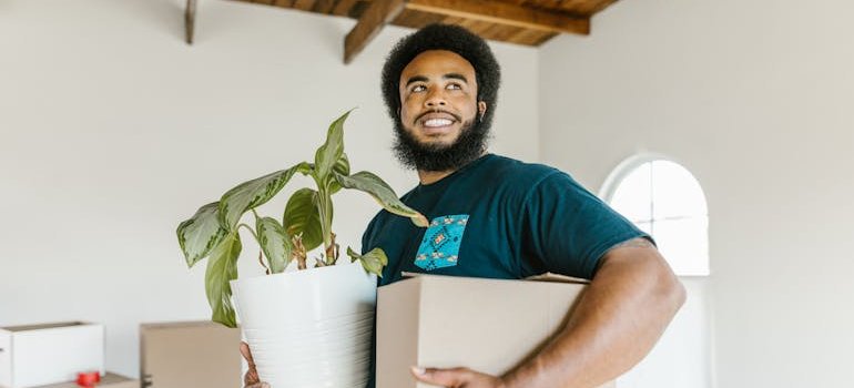 a mover holding a flower pot and a box