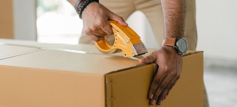person taping a box