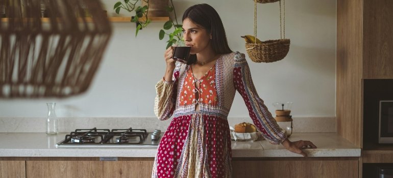 A woman drinking coffee in her new home.