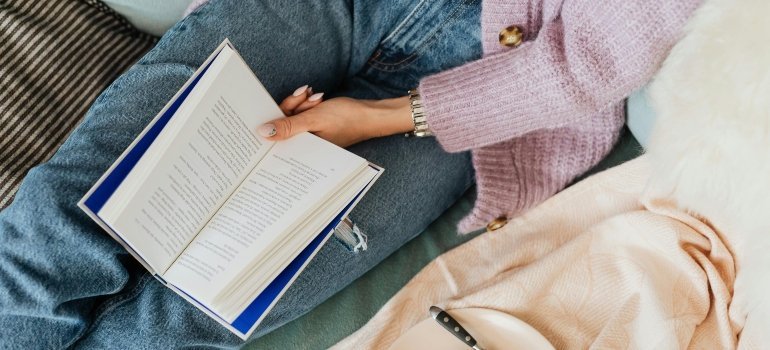 A picture of a book in a girls lap.