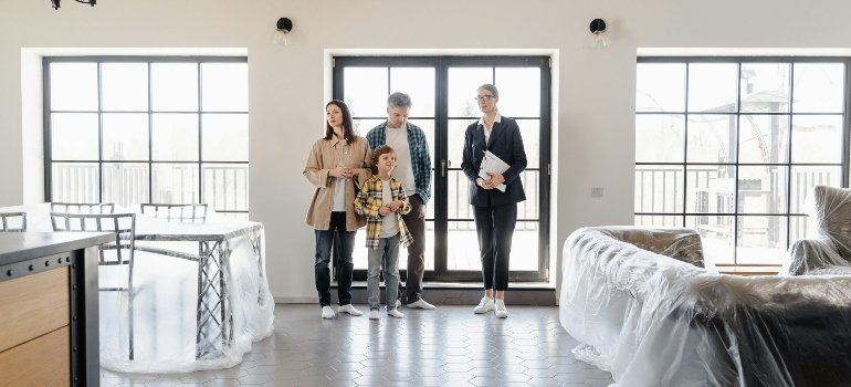 Family exploring a new house with a real estate agent while planning for a Maryland moving quote.