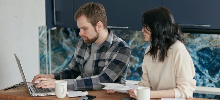 A couple looking for work on a computer.