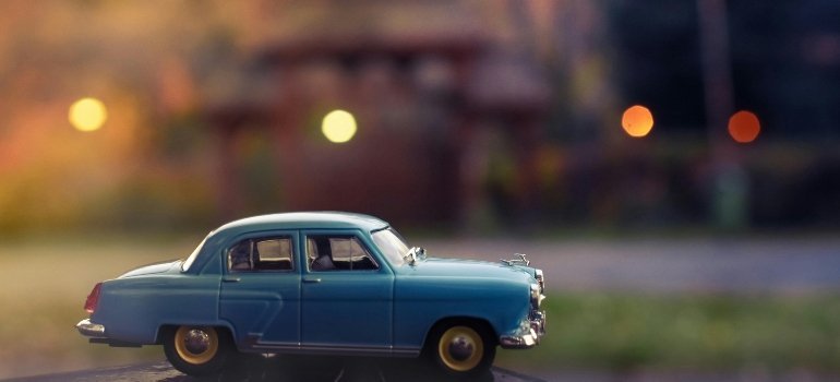Toy vintage car on a surface, symbolizing the start of a long-distance move.