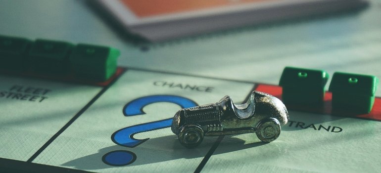 Monopoly game piece on question mark space, symbolizing uncertainty about moving expenses.