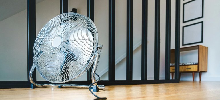 A floor fan placed in a home to keep cool during an unexpected summer move in Fredericksburg, helping reduce heat-related stress.