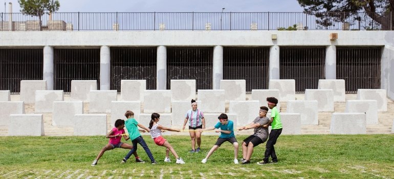 A group of kids playing tug-of-war on a school field, symbolizing community spirit and active youth engagement.