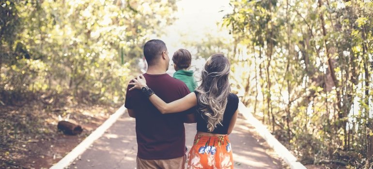 Rear view of a family walking along a tree-lined path, enjoying nature together — a reminder of What Makes Clinton MD a Great Place to Live.