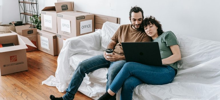 A couple is searching for the best cities for young couples in Northern Virginia on their laptop.