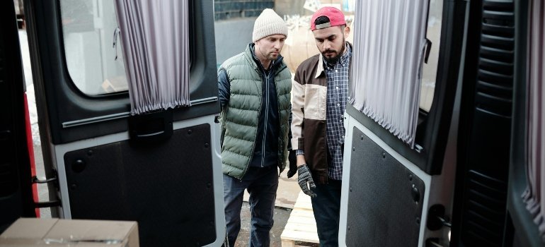 two boys packing things into the van