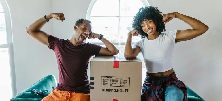 a girl and a boy next to the packing box