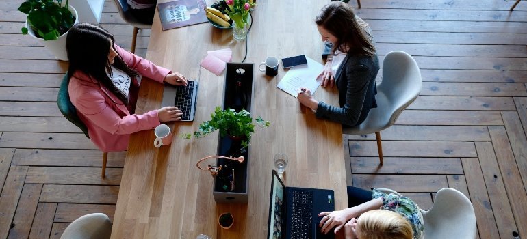 Three women are sitting at the coffee table.