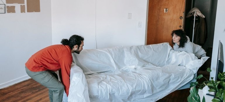 Couple lifting a couch