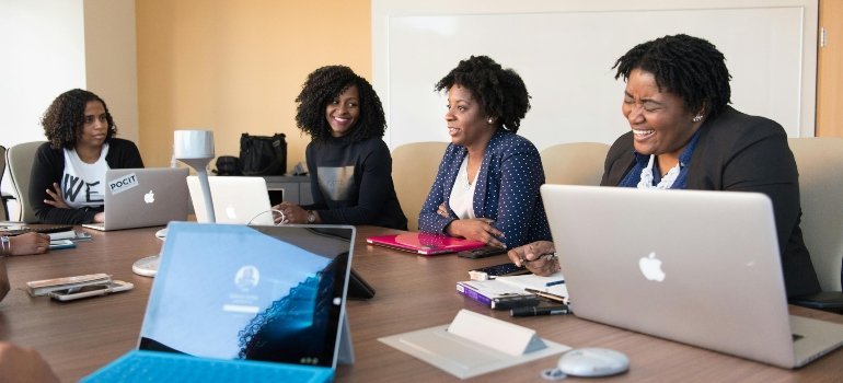Coworkers gathered in a conference room sharing ideas during a group meeting.