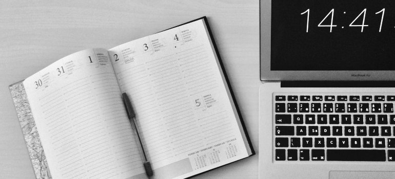 An open planner next to a laptop, showing how Businesses Benefit from Storage Rentals in staying organized.