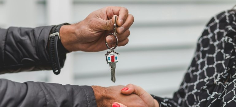 Hands exchanging house keys during a deal, celebrating the start of someone’s big new chapter.
