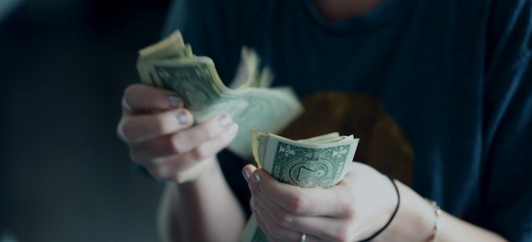 Person counting money because the moving rates in DC vary by season