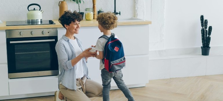 Smiling Mother and Son with Backpack in Kitchen