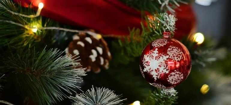Festive Christmas tree with red ornament prepared for organized holiday decoration storage