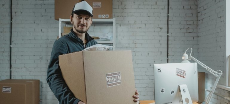 Man in jacket holding a cardboard box prepared for safe holiday decoration storage