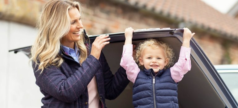 Child and adult in a car after moving from the suburbs to DC