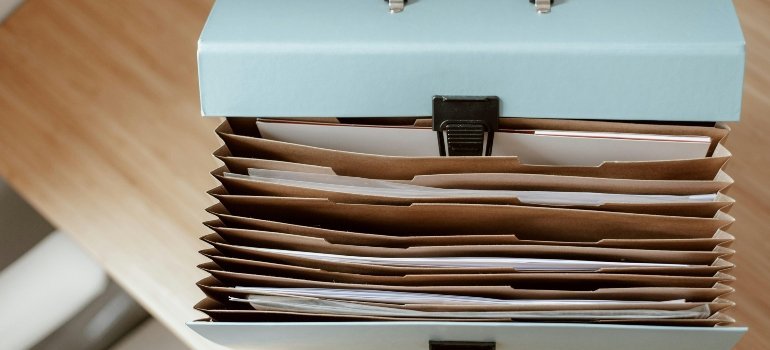 Stack of labeled folders prepared for moving day organization.