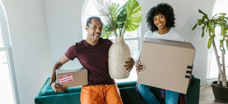 Couple sitting with packed boxes during military relocation in Washington DC home setup