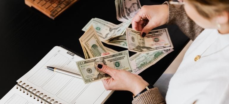 Woman counting money while making a home budget.