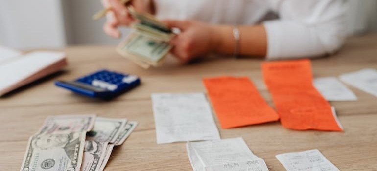 Woman counting money and calculating costs for Alexandria storage rentals.